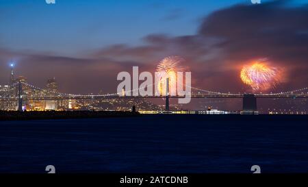 Quarto di luglio Fuochi d'artificio Sopra Bay Bridge e San Francisco Skyline visto da Alameda Island, California, Stati Uniti Foto Stock