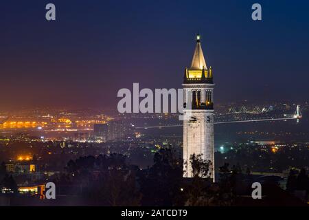 UC Berkeley Campanile Clock Tower e Bay Bridge a Dusk, Berkeley, California, Stati Uniti Foto Stock