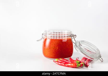 Peperoncino piccante salsa pasta harissa. Adjika. Cucina tradizionale tunisina, georgiana e araba. harissa rosa fatta in casa in un vaso di vetro. Foto Stock