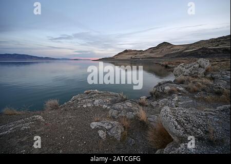 Formazioni rocciose e riflessi del Pyramid Lake, Nevada, in chiaro e tranquillo pomeriggio invernale. Foto Stock