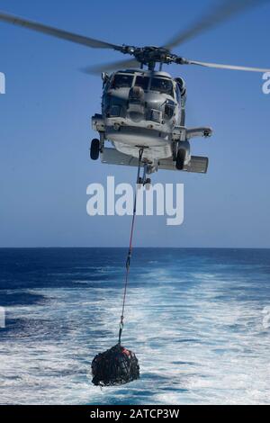 Oceano Pacifico (Gen. 27, 2020) Un MH-60R Sea Hawk, assegnato al "Wolf Pack" di Helicopter Maritime Strike Squadron (HSM) 75, solleva il carico dal ponte di volo del cacciatorpediniere USS Pinckney (DDG 91) 27 gennaio 2020 della classe Arleigh Burke. Pinckney, parte del Theodore Roosevelt Carrier Strike Group, è in fase di implementazione programmata per l'Indo-Pacific. (STATI UNITI Navy Photo by Mass Communication Specialist 3rd Class Erick A. Parsons) Foto Stock