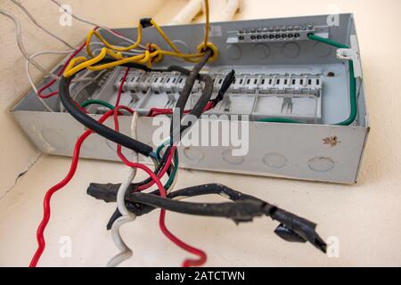 Un vuoto aperto elettricità scatola dei fusibili con cavi sul muro bianco. Quadro elettrico di comando con vuoto le scatole dei fusibili all'interno di un edificio abbandonato. Circ danneggiato Foto Stock