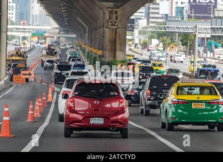 Bangkok, THAILANDIA, ottobre 10 2019, traffico su strada con restrizioni per la riparazione su strada. La vista posteriore del convoglio di automobili che cavalcano su un'autostrada in città. Foto Stock