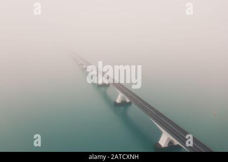 Bellissimo scatto del ponte Zeeland coperto di nebbia Paesi Bassi Foto Stock