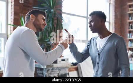Colleghi che lottano sul posto di lavoro, due uomini che lottano sul posto di lavoro Foto Stock