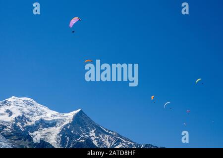 Parapendio in cerca di terme tra le cime innevate del Massiccio del Monte Bianco, Chamonix, Francia Foto Stock