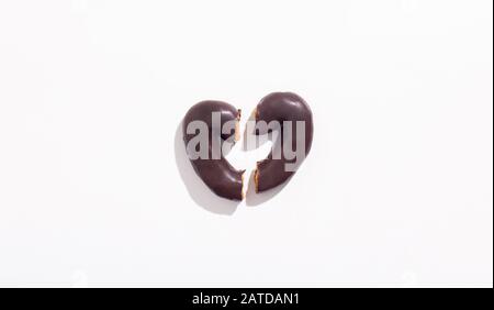 Cuore rotto di gustosi biscotti al cioccolato su sfondo bianco Foto Stock