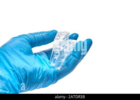 La mano contiene un set di vassoi dentari personalizzati per la sbianca dei denti. Isolato su sfondo bianco Foto Stock