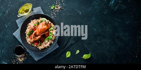 Quaglia al forno con farinata d'avena e verdure. Su sfondo nero. Vista dall'alto. Spazio libero per il testo. Foto Stock