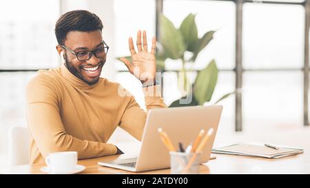 Sorridente afro manager facendo chiamata video di famiglia Foto Stock