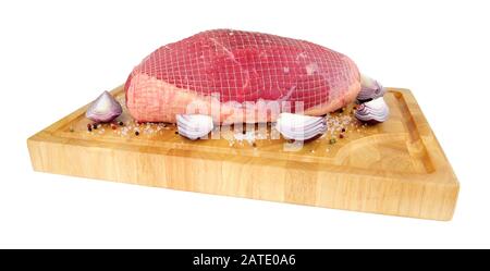 Giuntura di tostatura di manzo crudo su un tagliere di legno isolato su sfondo bianco Foto Stock