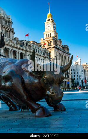 La Shanghai Bull di Arturo di Modica, con la storica Customs House e gli ex edifici di Hong Kong e Shanghai Banking Corporation sullo sfondo. Foto Stock