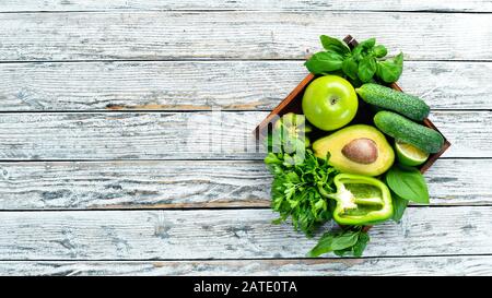 Frutta e verdura fresca e biologica. Avocado, kiwi, cipolla, lime, prezzemolo. Cibo biologico. Stile rustico. Vista dall'alto. Spazio libero per il testo. Foto Stock