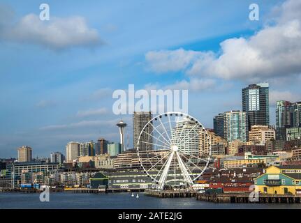 Lungomare e skyline di Seattle, con lo Space Needle che mostra attraverso i raggi della ruota della Grande ruota panoramica in primo piano. Immagine colorata Foto Stock