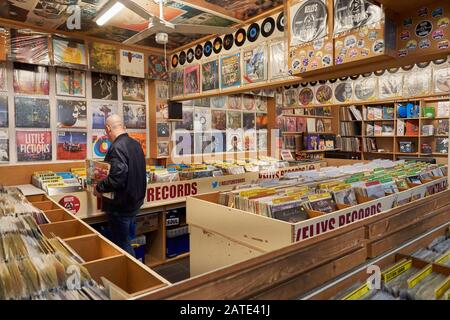 Shopping che sfoglia i dischi in vinile in Kelly's Records, Cardiff indoor Market Foto Stock