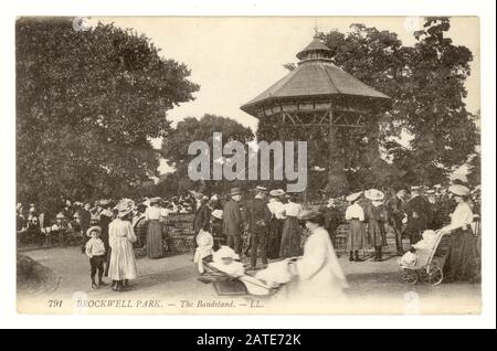 Originale cartolina edoardiana dei visitatori godendo di una giornata fuori nel parco Brockwell con chiosco e spettatori, Lambeth, Londra, circa 1910 Foto Stock