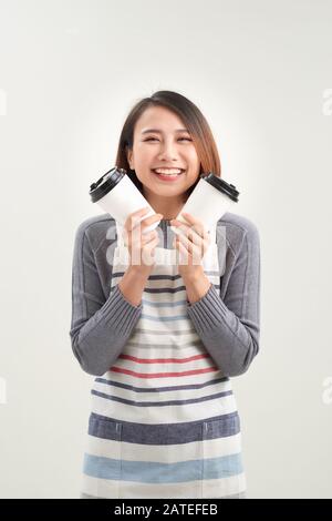 Primo piano foto bella sorprendente sua signora cameriera proprietario caffetteria tenere le mani braccia carta tazze calda bevanda invitare visita caffè indossare grembiule isolato w Foto Stock