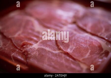 Fette di carne di maiale cruda su piatto Foto Stock