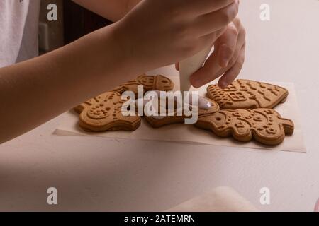 Un ragazzo di 10 anni smala i biscotti con una borsa culinaria. Fatto A Mano. Creatività dei bambini Foto Stock