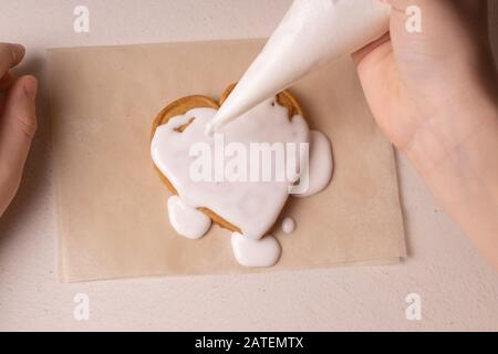 Un ragazzo di 10 anni smala i biscotti con una borsa culinaria. Fatto A Mano. Creatività dei bambini Foto Stock