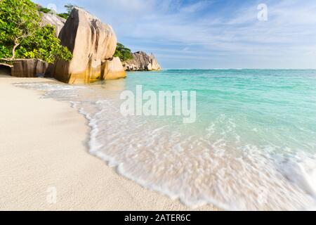 La spiaggia bianca perfetta Anse Source D'Argent a la Digue, Seychelles con le sue rocce di granito e la calda luce serale Foto Stock