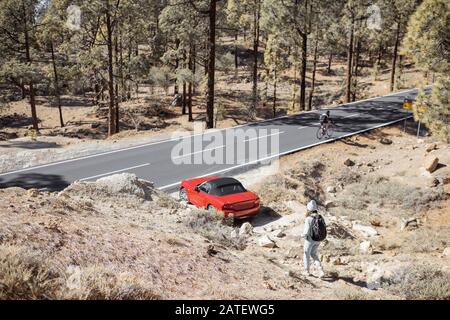 Donna che viaggia in auto sulla foresta vulcanica di montagna sull'isola di Tenerife, Spagna. Ampia visuale dall'alto Foto Stock