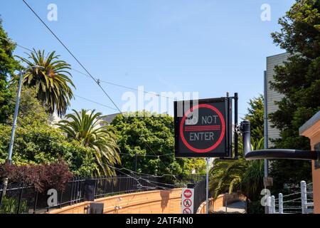 Non entrare nel segno dell'accendino al neon che conduce al tunnel pedonale in un ambiente soleggiato Foto Stock