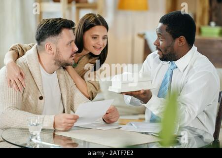 Giovane coppia con consulente ipotecario Foto Stock