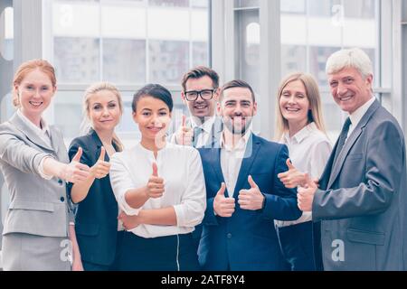Ritratto di business team di persone che mostra Thumbs up , Ufficio personale in piedi nella lobby Foto Stock