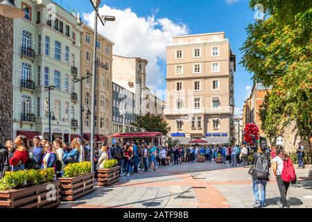 Viaggiatori e turisti attendono nella lunga linea per entrare nella Torre Galata nel quartiere Karakoy di Istanbul, Turchia. Foto Stock