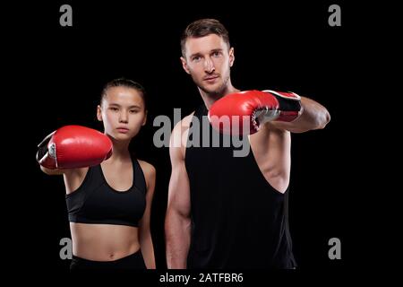 Giovane sportivo e sportivo in guanti da boxe e e abbigliamento sportivo Foto Stock