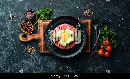 Tartare di manzo con tuorlo d'uovo. Cucina tradizionale. Vista dall'alto. Spazio libero per il testo. Foto Stock