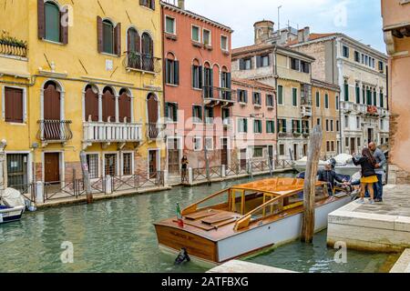 Bellissimo vecchio edificio lungo il canale rio de santa fosca, come persone a bordo di un taxi d'acqua nel quartiere di Cannaregio, Venezia, Italia Foto Stock