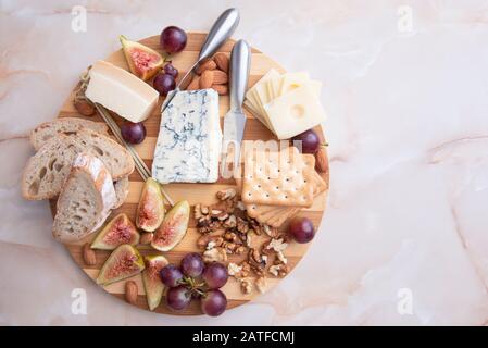 plateau di formaggi con noci, uva, fichi, mandorle e pane Foto Stock