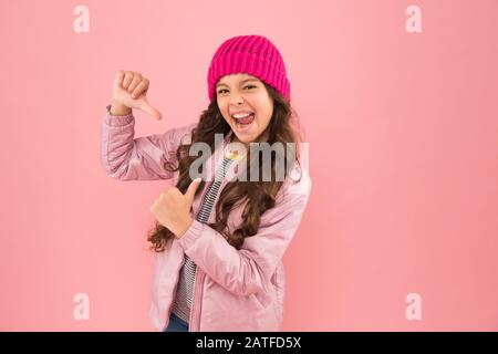 Il mio capo di abbigliamento Preferito. Pronto per l'inverno freddo. Clima freddo. Felice bambina rosa sfondo. Giacca piumino e cappello a maglia per bambini. Shopping invernale. Come vestirsi caldo in inverno. Foto Stock