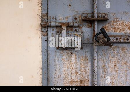 Primo piano di una portiera blu arrugginita e di un foro per la serratura Foto Stock