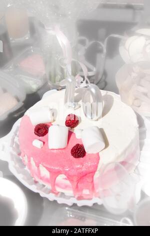 Torta rosa festiva con lamponi e con il numero dieci. Compleanno. Vacanza. Torta per una ragazza. Foto sfocata, bluer Foto Stock