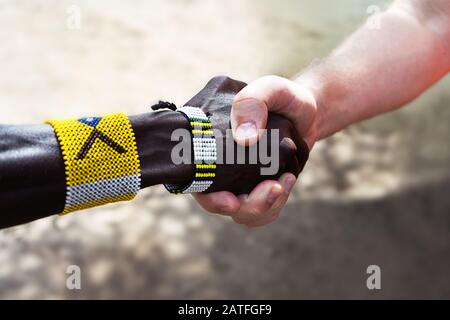 Stretta di mano di uomini africani ed europei o americani. Il concetto di amicizia e relazioni commerciali tra paesi e continenti. Foto Stock