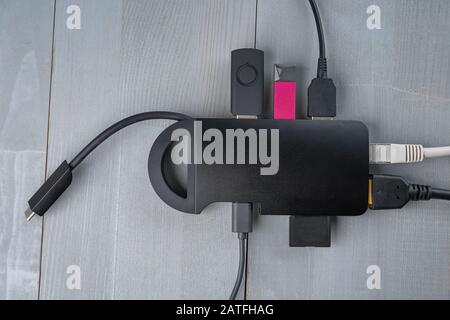 Adattatore o hub USB di tipo C con vari accessori collegati: Pendrives, hdmi, ethernet, cavi. Vista dall'alto a disposizione piatta. Foto Stock