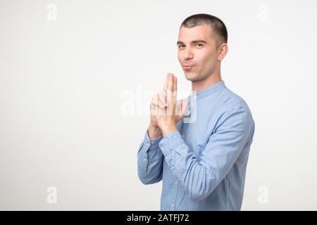 Divertente giovane ispanico che finge di avere un fucile. Divertimento e concetto giovanile Foto Stock