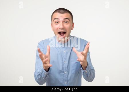 Successo, concetto di successo. Allegro uomo ispanico alzando le mani, avendo il volto pieno di felicità gioendo i suoi grandi successi. Studio Foto Stock