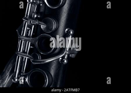 parte del corpo del clarinetto, con i meccanismi d'argento sul legno. Sfondo nero e spazio libero per il testo Foto Stock