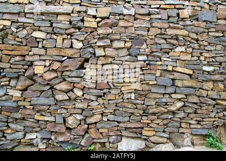 Sfondo di un muro di piccole pietre naturali Foto Stock