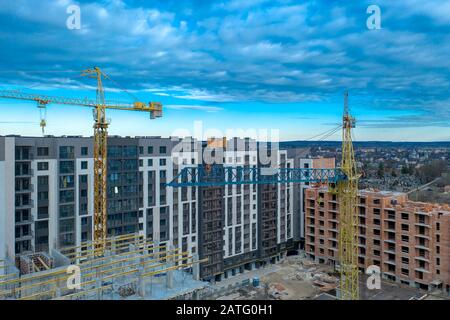 Sito in costruzione dello sfondo. Gru di sollevamento e di nuovi edifici a più piani. I.ndustrial sfondo Foto Stock