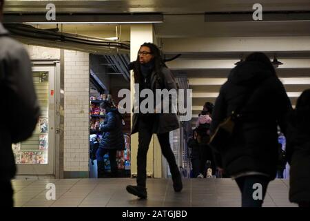 New York, NY / USA - 31 dicembre 2019: La donna acquista uno spuntino veloce dal negozio sotterraneo come la gente intorno alla sua corsa per arrivare al loro Foto Stock