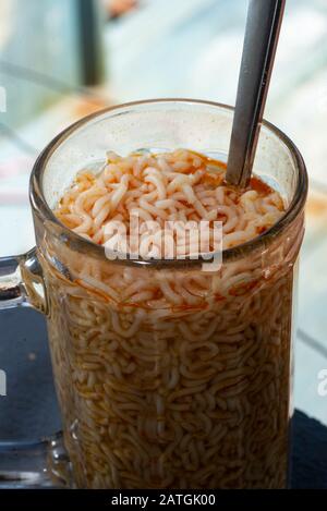 Spaghetti con cucchiaio d'argento in un vaso di vetro Foto Stock