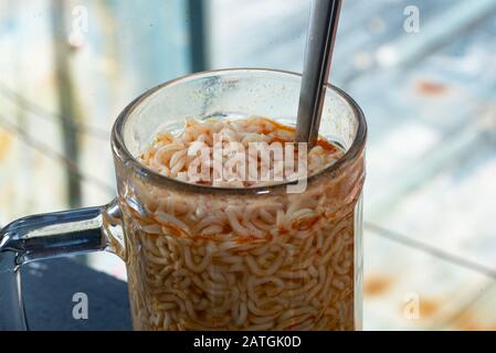 Spaghetti con cucchiaio d'argento in un vaso di vetro Foto Stock