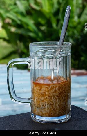 Spaghetti con cucchiaio d'argento in un vaso di vetro Foto Stock