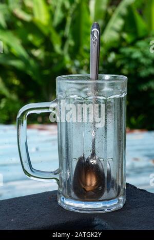 Cucchiaio d'argento in un vaso di vetro Foto Stock