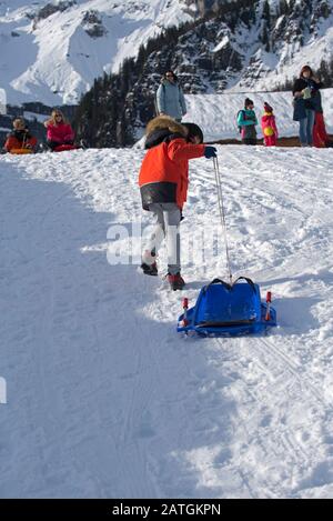 Ragazzo torna con slitta Foto Stock